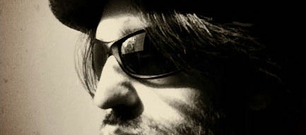 Closely cropped Black and white photo of Berdandy in a hat and sport sunglasses