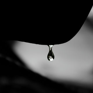 A drop of water falling off of a silhouetted chin